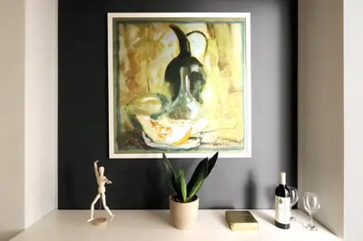 a painting on a wall above a desk with a plant at Piazzetta Margutta - My Extra Home in Rome