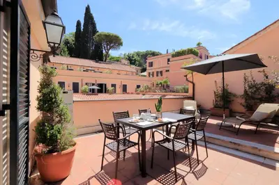 a patio with a table and chairs and an umbrella at Piazzetta Margutta - My Extra Home in Rome