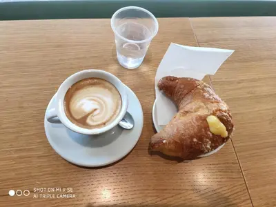 a cup of coffee and a pastry on a table at Ziani Vatican Boutique in Rome