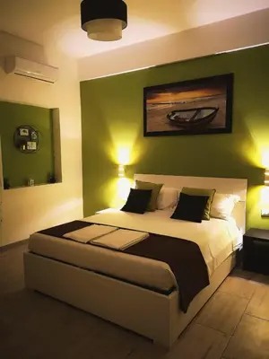 a bedroom with a bed with green walls and lights at The Royals in Rome