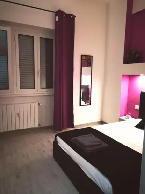 a bedroom with a bed with a red curtain at The Royals in Rome