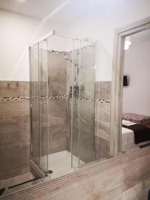 a glass shower in a room with a bed at The Royals in Rome