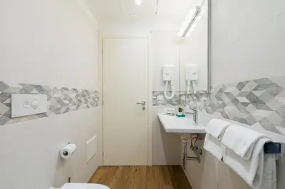 a bathroom with a sink and a toilet and a mirror at Demetra Eco Guest House in Rome