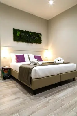 a bedroom with a large bed with purple pillows at Demetra Eco Guest House in Rome