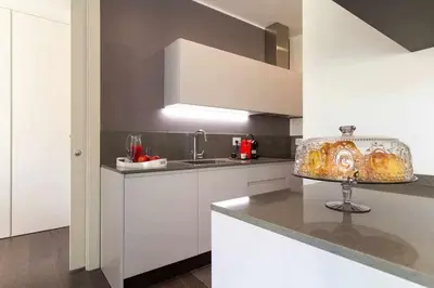 a kitchen with white cabinets and a counter top at AventinoHome in Rome