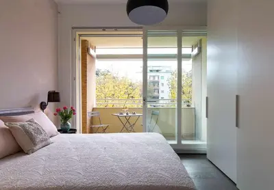 a bedroom with a bed and a view of a balcony at AventinoHome in Rome