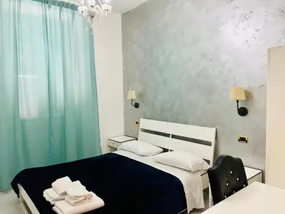a bedroom with a black and white bed and a window at Hotel Pisa in Rome