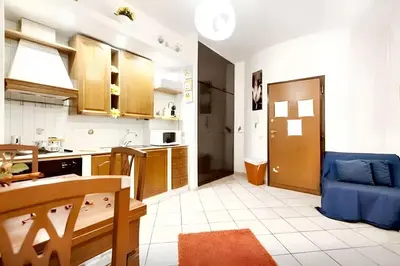 a kitchen with a table and a blue couch in a room at Comfortable studio in Rome 40.2 m² with wifi in Rome