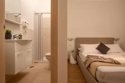 a bedroom with a bed and a bathroom with a sink at Domus Veneto Rome in Rome