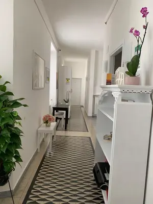 a hallway with white walls and a black and white rug at Mama Roma Domus in Rome
