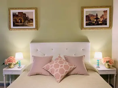 a bedroom with a bed with two pictures on the wall at Mama Roma Domus in Rome
