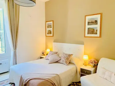 a bedroom with a bed with two lamps and a chair at Mama Roma Domus in Rome