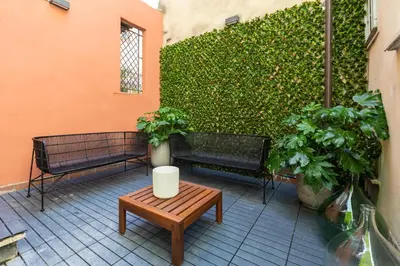 a patio with two benches and a table and plants at Louly Spanish Steps in Rome