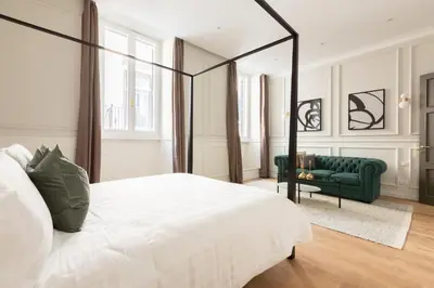 a bedroom with a white bed and a green couch at Louly Spanish Steps in Rome