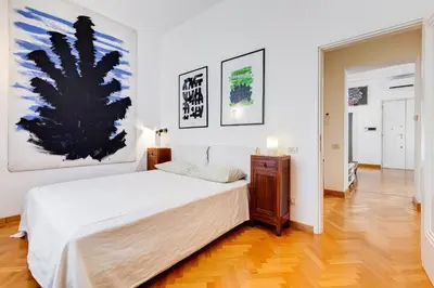 a bedroom with a bed and a painting on the wall at Colosseum Terrace Apartment in Rome