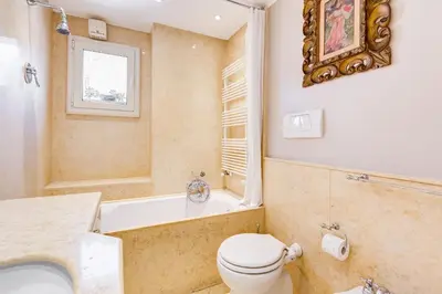 a bathroom with a toilet and a tub and a sink at Colosseum Terrace Apartment in Rome