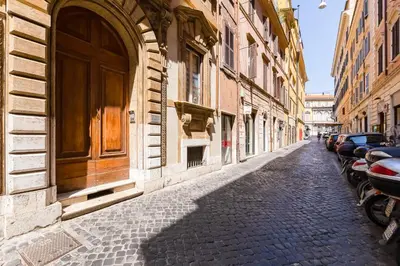 a cobblestone street in a city with cars parked at Colosseum Terrace Apartment in Rome