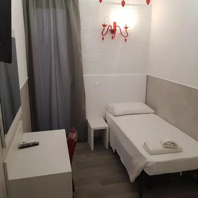 a small room with two beds and a table at Rubino Guest House in Rome