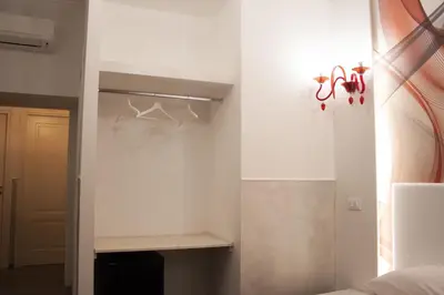 a bedroom with a white wall and a closet at Rubino Guest House in Rome