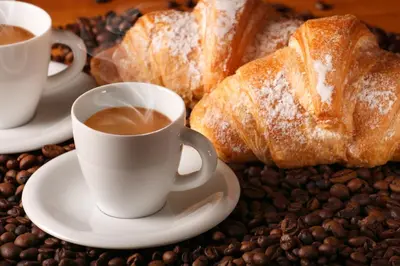 a table topped with cups of coffee and bread at Rubino Guest House in Rome