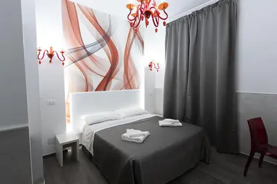 a bedroom with a bed with a painting on the wall at Rubino Guest House in Rome