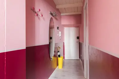 a hallway with pink walls and a yellow trash can at Apt.Prati L.T. (Vatican and center) in Rome