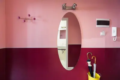 a bathroom with a pink wall with a mirror at Apt.Prati L.T. (Vatican and center) in Rome