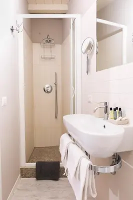 a white bathroom with a sink and a shower at Apt.Prati L.T. (Vatican and center) in Rome