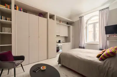 a bedroom with a bed and a chair and a table at Apt.Prati L.T. (Vatican and center) in Rome