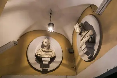 two statues on the side of a wall with mirrors at Royal Piazza di Spagna in Rome