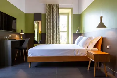 a bedroom with a bed and a desk and a window at MODO Rooms & Suite Rome in Rome