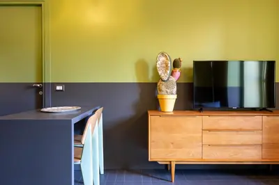 a living room with a tv and a wooden dresser at MODO Rooms & Suite Rome in Rome