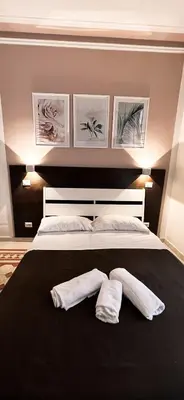 a large bed with two white towels on it at Novaroma by Local Domus in Rome