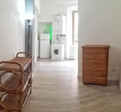 a living room with a dresser and a kitchen with appliances at Novaroma by Local Domus in Rome