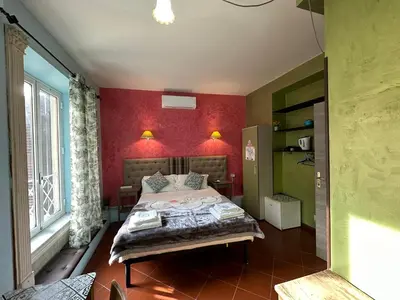 a bedroom with a bed with a red wall at Signor Suite Colosseo in Rome