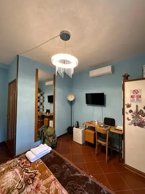 a room with a bed and a desk and a chandelier at Signor Suite Colosseo in Rome
