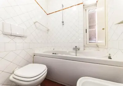 a bathroom with a toilet and a tub and a sink at Signor Suite Colosseo in Rome