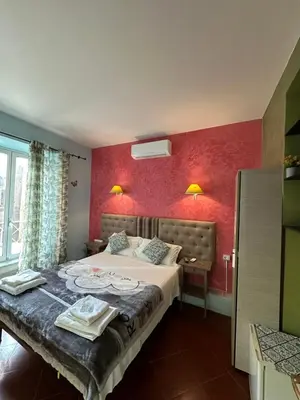 a bedroom with a bed and a red wall at Signor Suite Colosseo in Rome