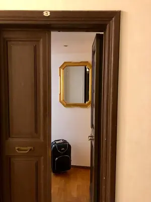 an open door with a mirror and a suitcase in a room at Sant’Onofrio - Trastevere Vatican apartment Roma in Rome