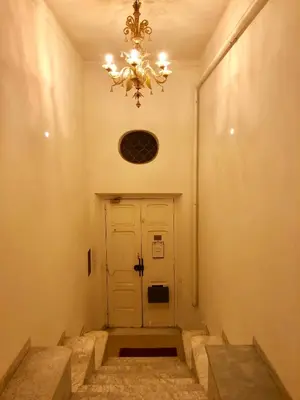 a hallway with a white door and a chandelier at Sant’Onofrio - Trastevere Vatican apartment Roma in Rome