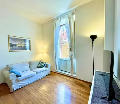 a living room with a white couch and a large window at Sant’Onofrio - Trastevere Vatican apartment Roma in Rome