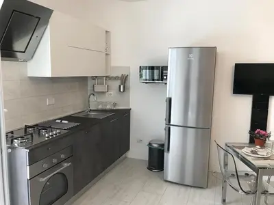 a kitchen with a stainless steel refrigerator and a table at CASA DONATELLO con TERRAZZO in Rome