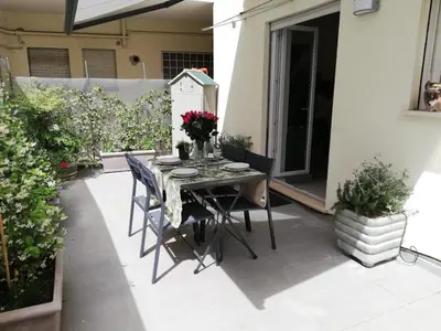 a table and chairs on a patio with flowers at CASA DONATELLO con TERRAZZO in Rome