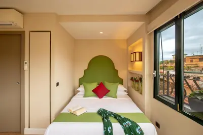 a bedroom with a bed with a green headboard at Nido del Gambero - Your Suite with View in Rome