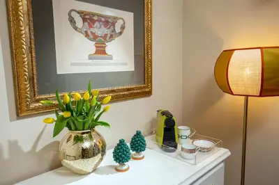 a vase with flowers on a table with a lamp at Nido del Gambero - Your Suite with View in Rome