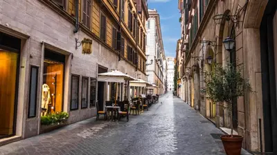 an empty street in a city with tables and chairs at Nido del Gambero - Your Suite with View in Rome