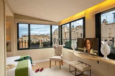 a bedroom with a bed and a desk and windows at Nido del Gambero - Your Suite with View in Rome