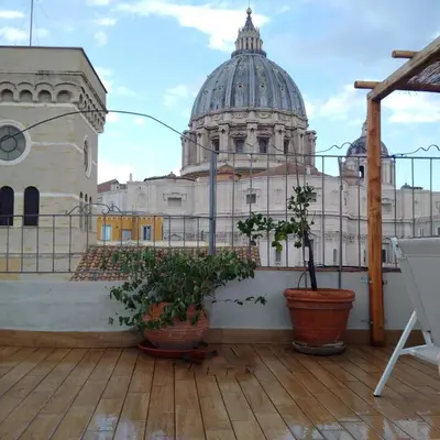 a balcony with potted plants and a domed building at La CasUPOLA Saint Peter's Quiet Room in Rome