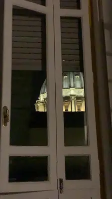 a reflection of a building in the window of a door at La CasUPOLA Saint Peter's Quiet Room in Rome