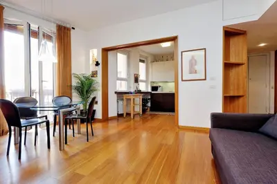 a dining room and living room with a table and chairs at Angelico Family Apartment in Rome